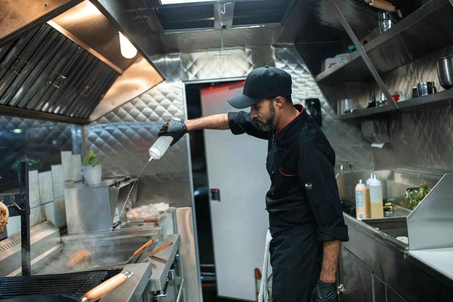 Cuisine professionnelle en activité sous une hotte d'extraction inox